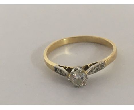A gold ring set with an old cut solitaire diamond 0.20 of a carat approximately flanked by chip diamonds weight 2g unmarked g