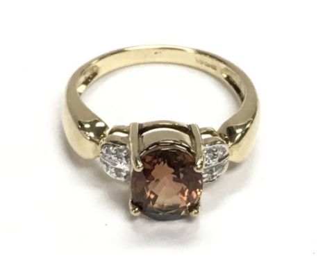9ct yellow gold ring set with an oval orange tourmaline and diamonds. Tourmaline 1.20ct Approx. Diamonds 0.06ct Approx. Ring 