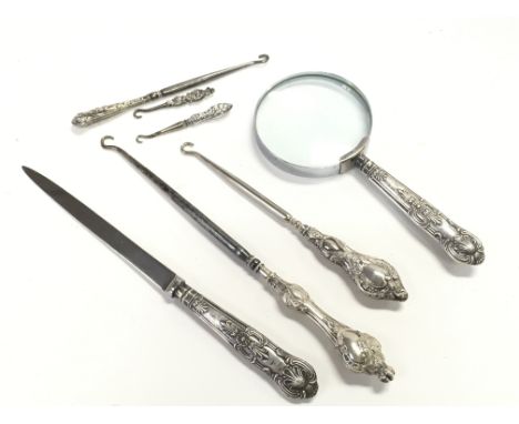 A collection of silver items to include silver handled magnifying glasses and button hooks. This lot cannot be posted