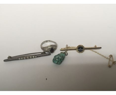 An unmarked gold bar brooch set with a striped polished cabochon stone and chip diamonds. a silver ring small pendent and bar