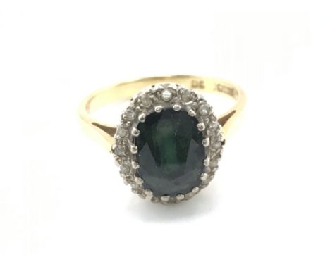 An 18ct gold green sapphire a diamond chip ring. Size N 1/2 and 4.63g Postage A