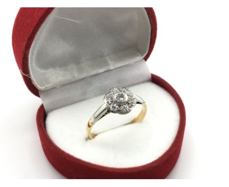 An 18 carat yellow and white gold Daisy cluster ring set with diamonds, size R, 2.7g. Postage category a