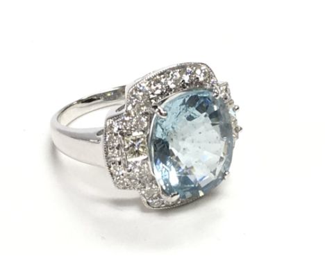 18ct white gold dress ring set with a large oval cushion aquamarine surrounded by Princess cut and RBC diamonds. Aquamarine 6