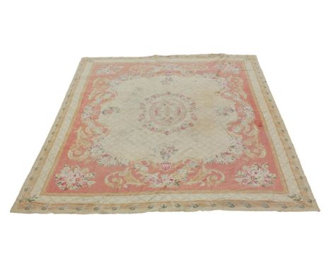 An Aubusson tapestry rug, with oval medallions and floral swags, on a cross hatched pattern on yellow ground, the borders of 