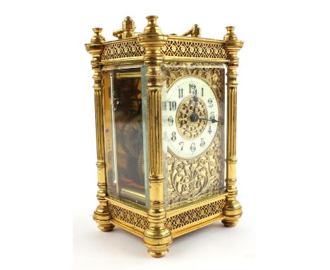 An early 20th century brass carriage timepiece, the foliate decorated face with white chapter ring and black numerals, 15cm h
