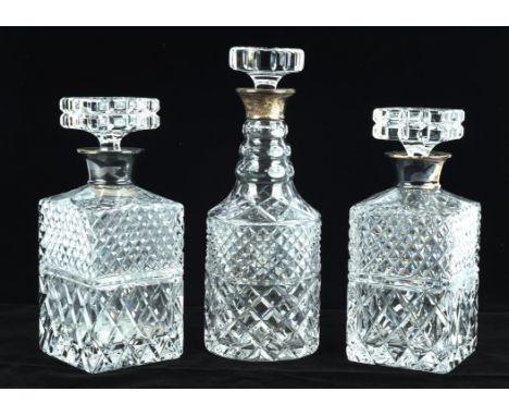 A pair of crystal decanters and stoppers, each of square form mounted with hallmarked silver collars, 23cm high, another 'Mal