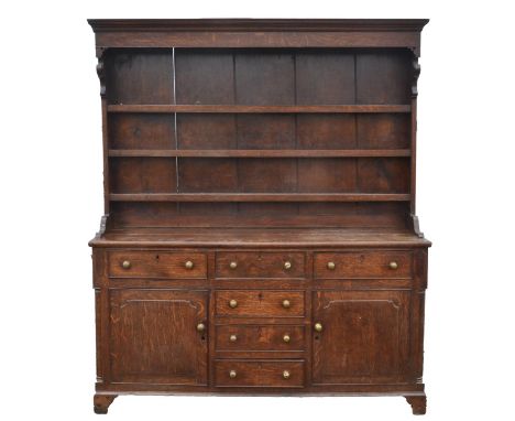 A George III oak dresser, early 19th century, North Wales, the rack pine backed and above a base with an arrangement of six d