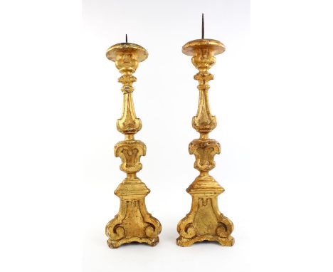 A pair of Louis XIV style gilt wood altar candle sticks, late 19th century of carved triform shape.  56cm high.  (2)Condition