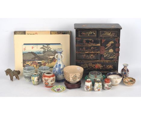 A small kuro-nuri cabinet, 30 cm high, Meiji Period; together with a quantity of ceramic stands and mainly Japanese ceramics,