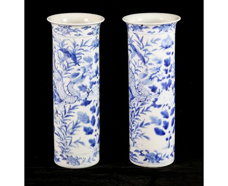 A pair of blue and white vases of cylindrical form, each one decorated with two confronting dragons, both 25.5 cm high; one v