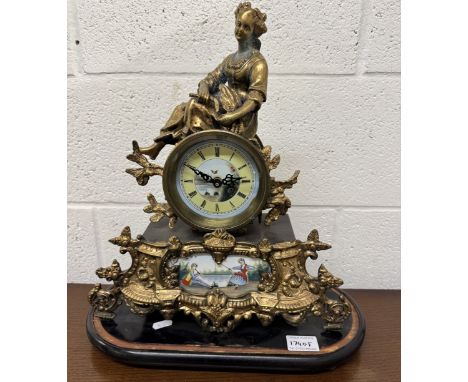 A 19th century gilt mantel clock surmounted figure with painted porcelain panels.