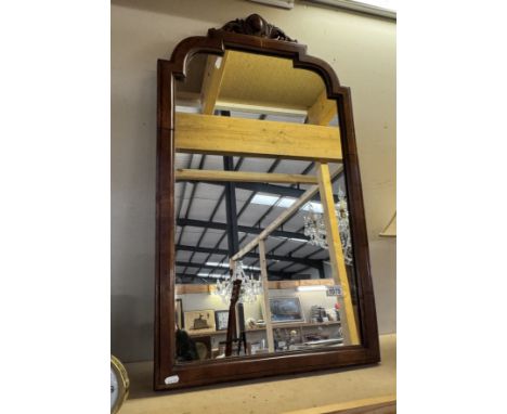 A wall mirror with wooden surround