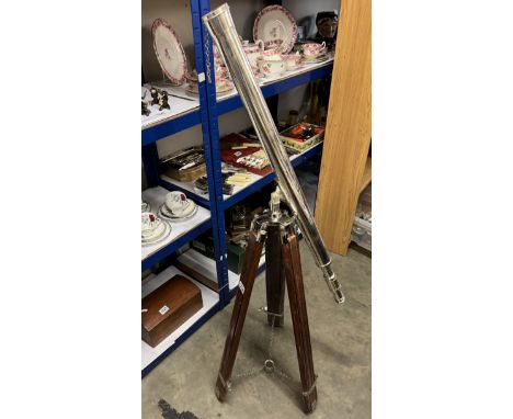 A large silver plated telescope on teak tripod