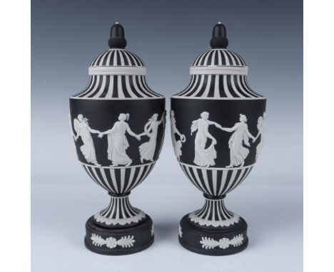 Two white porcelain footed vases dipped in a black finish. Depicts, in white raised reliefs, maidens dancing. Includes origin