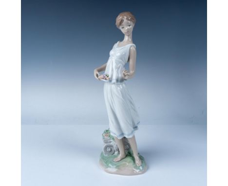 Lladro Flowers for a Goddess figurine, model number 07709, depicts a graceful woman holding delicate pastel flowers, embodyin