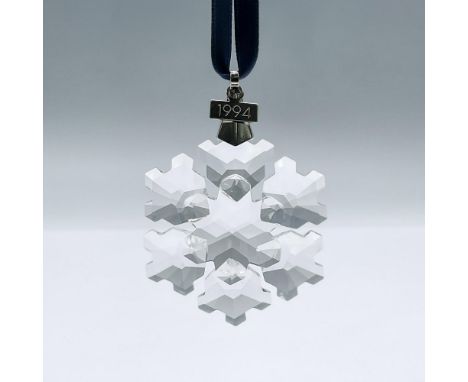 This limited edition clear crystal snowflake ornament features 6 points, a metal tag with a 1994 engraving, and a blue satin 