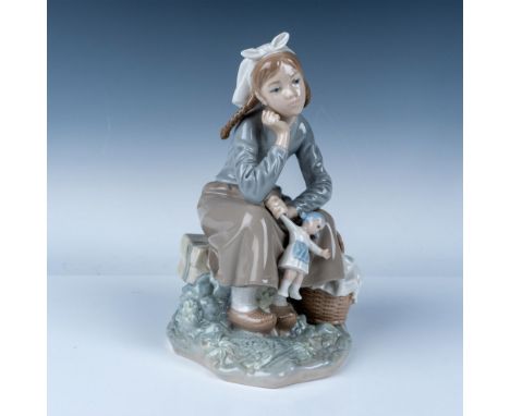 Lladro porcelain figurine, number 1001211, featuring a seated young girl with pigtails holding a small doll while resting bes