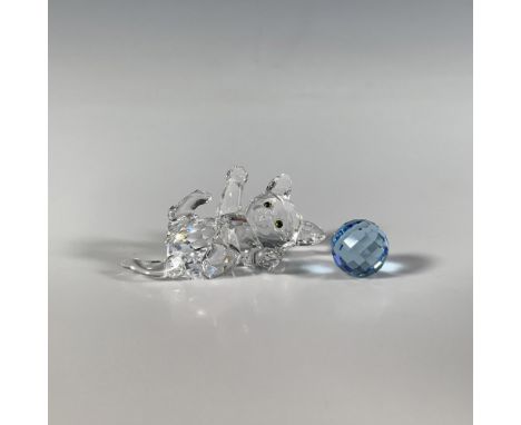 A clear faceted crystal figure of a cute playful kitten, adorned with green eyes and accompanied by its blue toy ball. Swarov