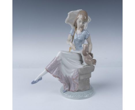 Lladro Picture Perfect figurine, model number 07612, depicts an elegant young woman seated on a bench, holding a delicate par
