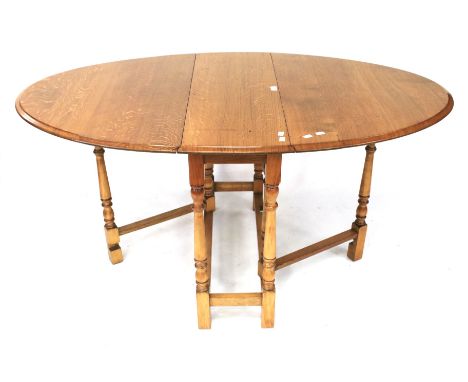 A light oak gate leg dining table. Of oval form, L89cm x D34cm x H76cm