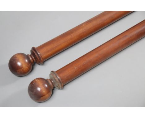 A pair of vintage wooden curtain-poles, each with spherical terminals, 236cm long.