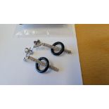 Pair of earrings in white metal which is assumed to be silver with diamond-like stones and black rin