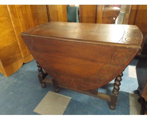 An Oval Oak Gate Leg Drop Leaf Dining Table with Barley Twist Supports and Carved Border, 105cm Wide