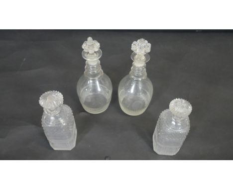 Two pairs of cut crystal decanters. Including a pair of Georgian blown glass three ring decanters with floral design stoppers