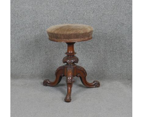 A Victorian carved walnut revolving adjustable piano stool on tripod cabriole base. h50 d45 