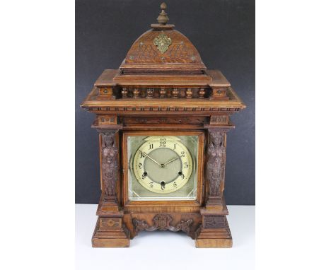 Early 20th century cased architectural mantel clock with two carved maiden figureheads, glass sides, on stepped plinth base b
