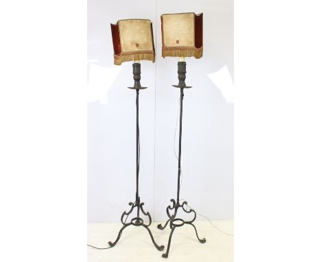 Pair of wrought iron scroll tripod base floor lamps with old deed type fringed lamp shades, H 176cm