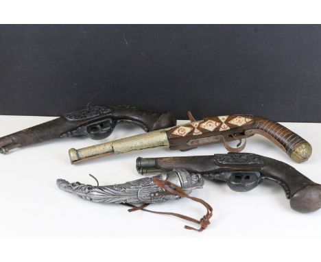 Three vintage reproduction non firing replica guns together with a white metal powder flask.