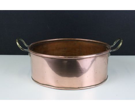 Copper oval pot or planter with rolled rim and twin brass loop handles, 34cm long