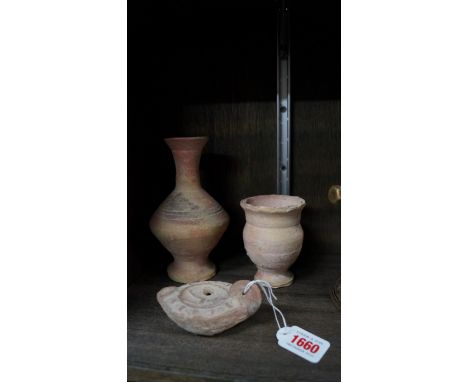 Antiquities: a Roman style oil lamp; and two other vases, largest 16.5cm high. 