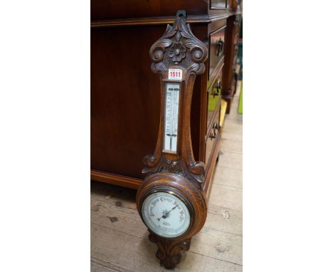 A carved oak aneroid wheel barometer. 