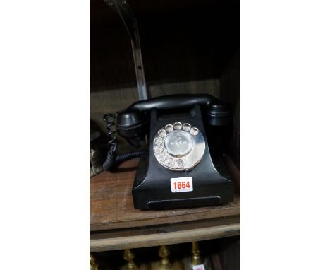 A vintage black Bakelite telephone.