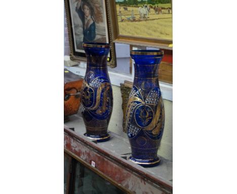 A pair of large blue glass vases, decorated with gilt and white enamel, 54cm high. 