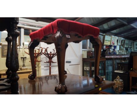 An 18th century style carved mahogany and button upholstered stool, on cabriole legs with ball and claw feet. 
