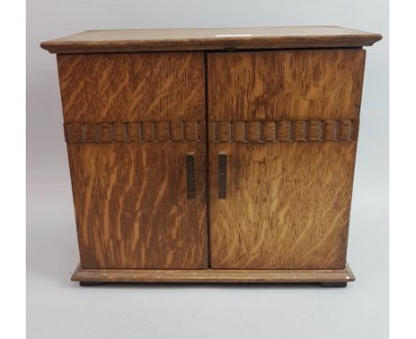 AN OAK SMOKERS' CABINET, with two doors; along with an oak cigar box and a small mantel clock (3)