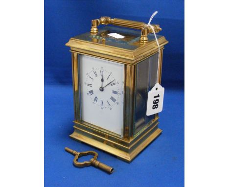 A four glass brass repeater carriage clock with white enamel dial striking on a gong.