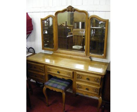 A Continental oak triple mirrored dressing table and stool.
