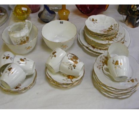 An English ceramic tea service with gilt floral decoration on a white ground and having a scalloped design (approx. 37 pieces