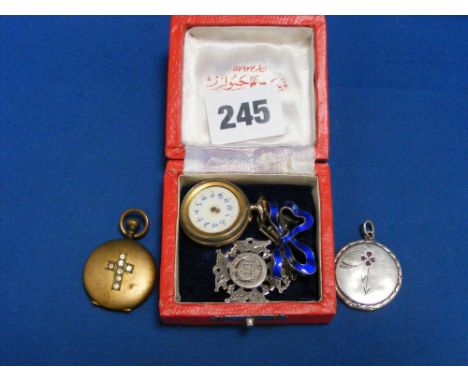 A silver watch fob, an enamel ladies fob watch (A/F), a silver locket and a gilt locket.
