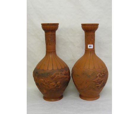 A pair of large terracotta vases in the Oriental taste with elongated necks above baluster bodies and having overlaid decorat