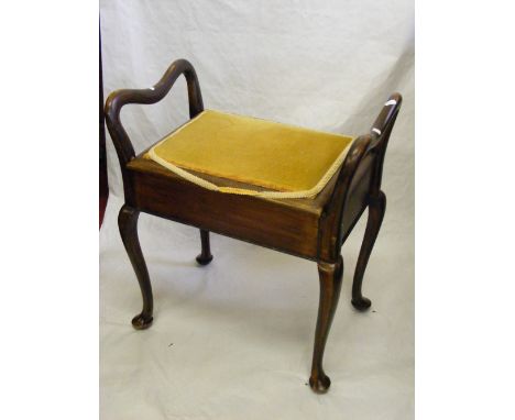 A piano stool with curved arms and cabriole supports.