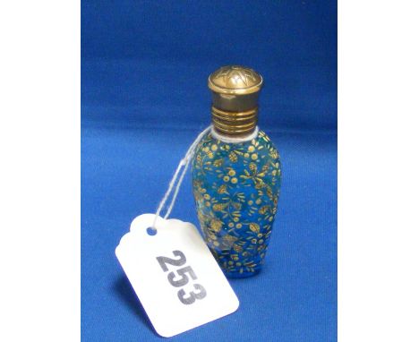 A Victorian blue glass scent bottle with enamel decoration with hinged top.