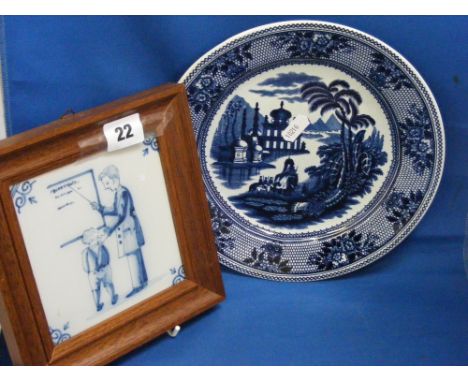 A Maastricht Delft blue and white plate in 'Delhi' pattern, plus a Delft blue and white tile in a wooden frame depicting a te