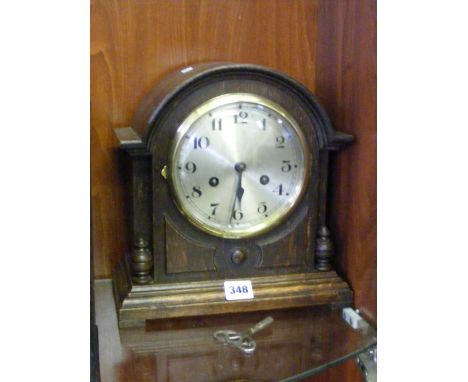 A dome topped Edwardian oak cased mantel clock.