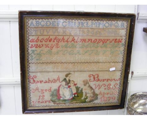 A framed and glazed sampler dated 1879.