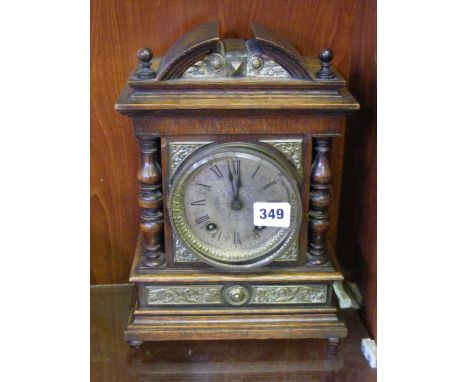 An Edwardian mantel clock with decorative metal mounts.  